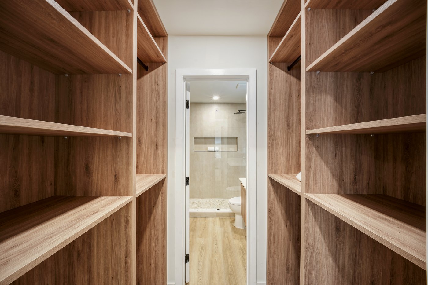 Interior of a walk-in wardrobe, walnut grain reading floor to ceiling