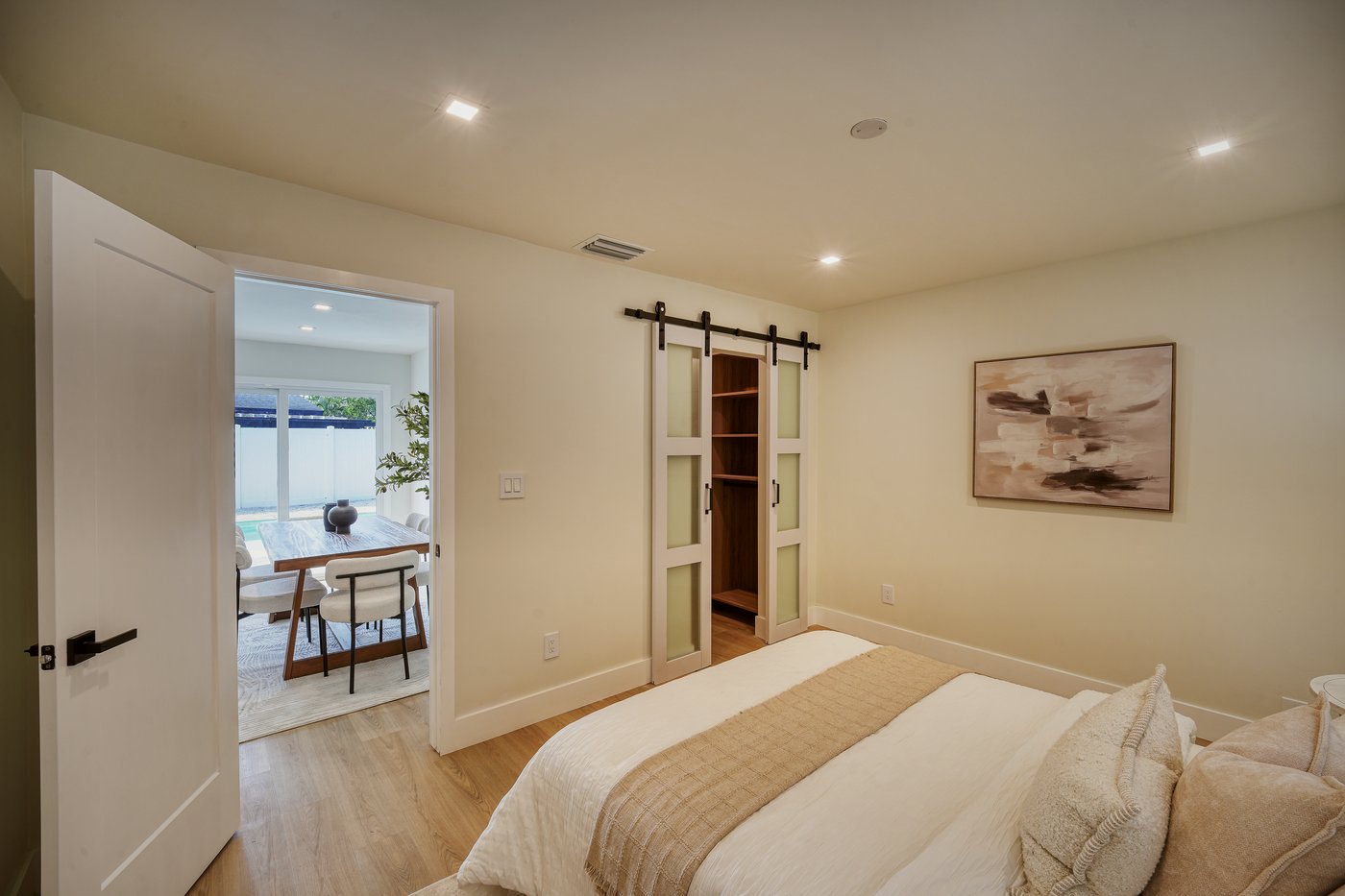 Bedroom with a glass-paneled sliding door opening to the living area